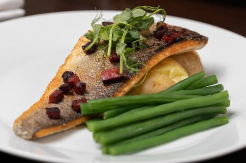ein weißer Teller mit einem Stück Toast und grünen Bohnen in der Unterkunft The Lawrence in Burnley