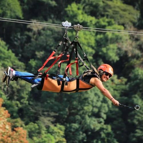 a person flying through the air on a zip line at Pousada Alvorada Brotas - e agendamento das atividades turísticas in Brotas