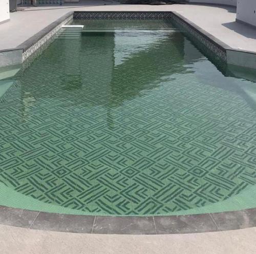 una piscina de agua con un patrón verde en el suelo en Hotel Maria del Rocio en Veracruz