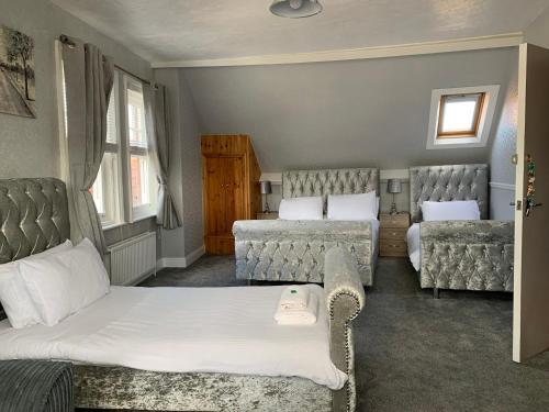 um quarto de hotel com duas camas e duas cadeiras em Grosvenor Hotel em Robin Hood's Bay