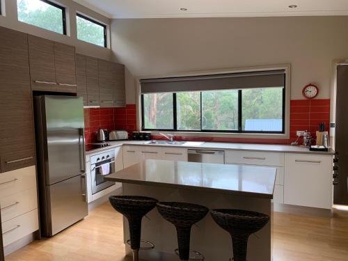a kitchen with a stainless steel refrigerator and a counter at The Lodges Two in Halls Gap