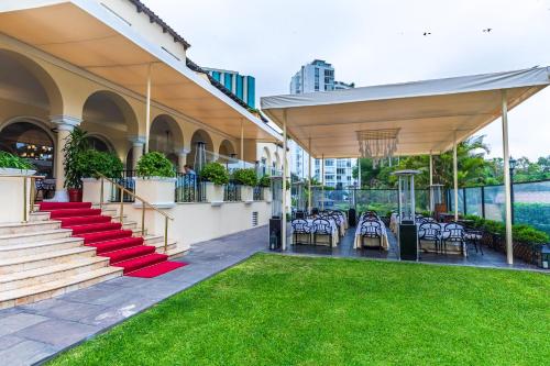 an outdoor patio with tables and chairs and grass at Country Club Lima Hotel – The Leading Hotels of the World in Lima
