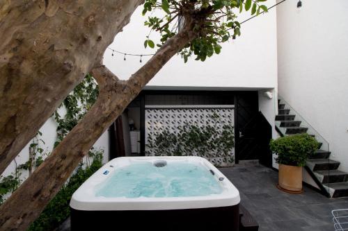 a jacuzzi tub sitting on a patio next to a tree at Hotel Casona Independencia in Guadalajara