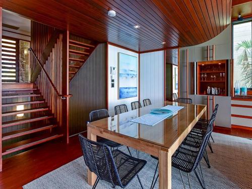a dining room with a large wooden table and chairs at Yacht Club Villas on Hamilton Island by HIHA in Hamilton Island