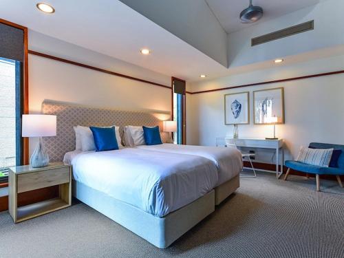 a large bedroom with a large bed and a desk at Yacht Club Villas on Hamilton Island by HIHA in Hamilton Island