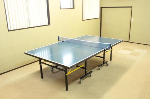 two ping pong tables in a room with a door at Miyajima Seaside Hotel in Miyajima