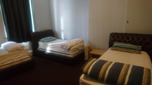 Ένα ή περισσότερα κρεβάτια σε δωμάτιο στο Backpackers Imperial Hotel