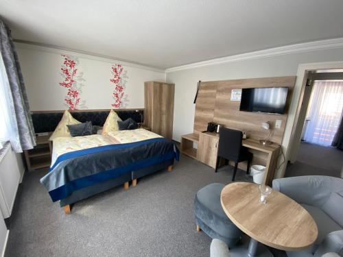 Hotel Mocca-Stuben في هيلغولاند: غرفة نوم بسرير ومكتب وطاولة