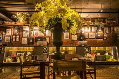 a table with a large vase with yellow flowers on it at Rosa Malacca in Melaka