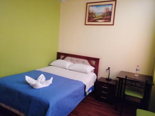 a bedroom with a bed with a white flower on it at Hostal Bolívar Inn in Quito
