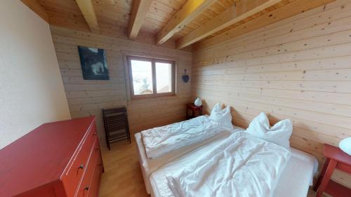 a bedroom with a bed and a wooden wall at Alpenlodge in Belalp