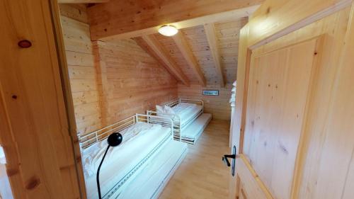 ベラルプにあるAlpenlodgeの木造キャビン内のベッド2台が備わる部屋