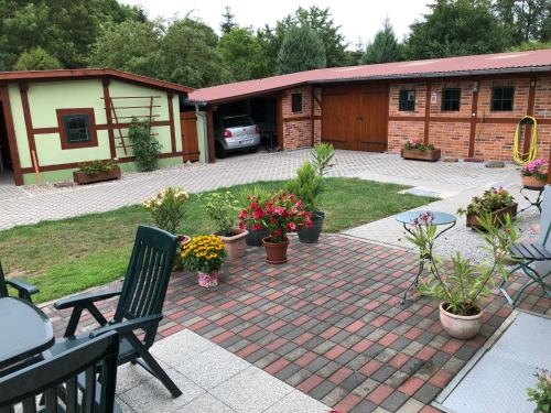 a patio with a table and chairs and some plants at Fewo Ramin in Felchow