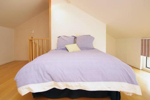 a bed with a purple comforter in a room at Adelaide close CBD Large Private Studio Apartment in St Peters in Norwood