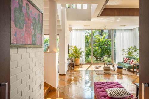a living room with a purple couch and a large window at La Maroma 3 BHK Splendid Villas in Anjuna - Pvt Pool- Garden & Caretaker in Vagator