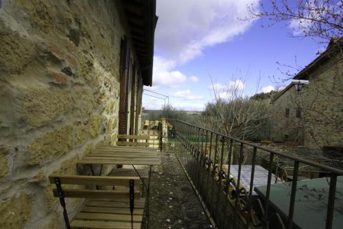 a balcony with wooden benches on a building at La Casa nel Borgo in Monticchiello