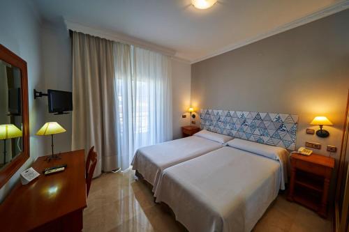 a hotel room with a bed and a television at Hotel Bajamar Centro in Nerja