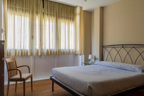 a bedroom with a bed and a chair and a window at Paseo Butrón by Basquelidays in Hondarribia