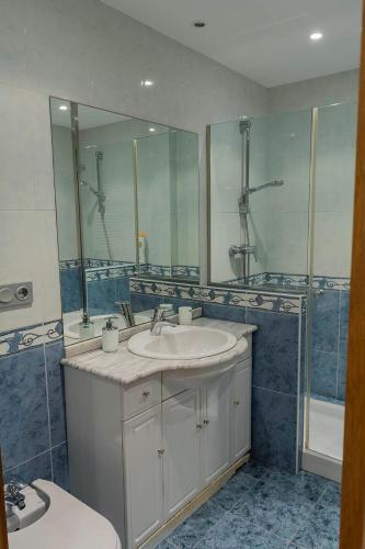 a bathroom with a sink and a mirror and a tub at Paseo Butrón by Basquelidays in Hondarribia