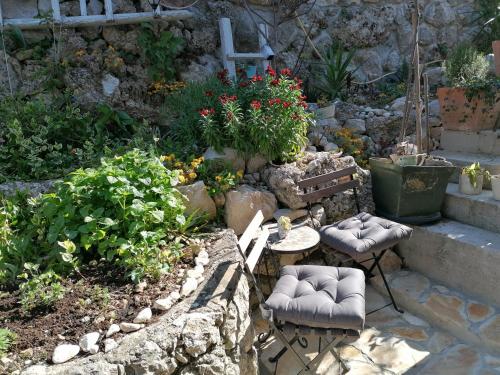 a garden with a table and chairs and plants at Mala Cele in Podgora