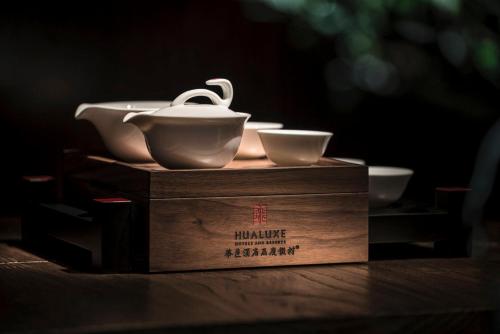 a box with two bowls and a tea pot on it at HUALUXE Yangjiang City Center in Yangjiang