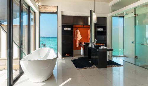 a bathroom with a tub, toilet and shower stall at Angsana Velavaru – All Inclusive SELECT in Dhaalu Atoll