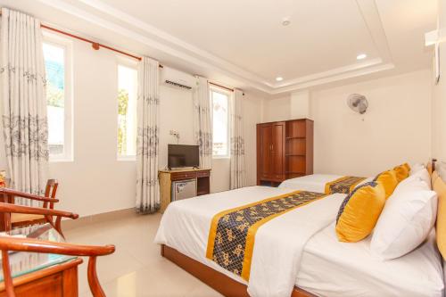 a bedroom with a bed and a tv and windows at Hoa De Nhat Hotel- Sân Bay Tân Sơn Nhất in Ho Chi Minh City
