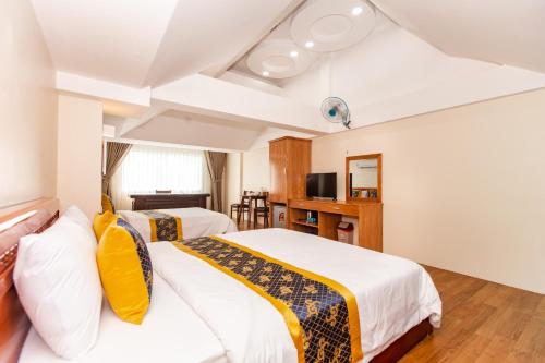 a hotel room with two beds and a television at Hoa De Nhat Hotel- Sân Bay Tân Sơn Nhất in Ho Chi Minh City