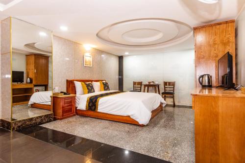 a bedroom with a bed and a television in a room at Hoa De Nhat Hotel- Sân Bay Tân Sơn Nhất in Ho Chi Minh City