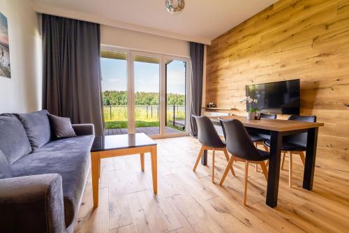 a living room with a couch and a table at Apartamenty Mazurskie Klimaty (Cud Natury) in Tomaszkowo