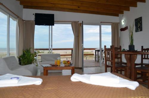 uma sala de estar com duas camas e vista para o oceano em Marina de las Pampas em Mar de las Pampas