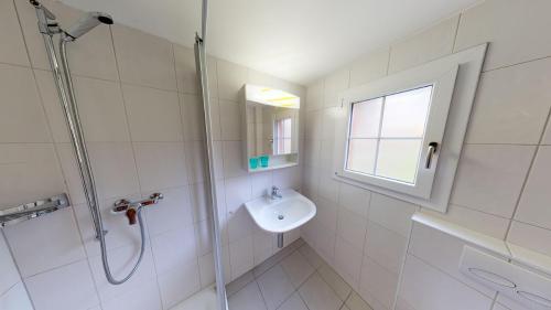 uma casa de banho branca com um lavatório e um chuveiro em Bergestille em Blatten bei Naters