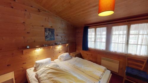 um quarto com uma cama num chalé de madeira em Bergestille em Blatten bei Naters