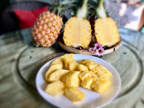 a plate of fruit on a table with a plate of pineapple at Mei Nong Villa in Meinong