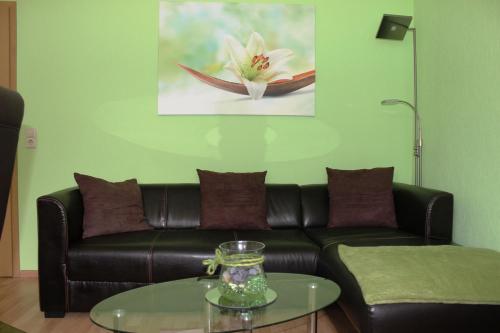 - un salon avec un canapé en cuir et une table en verre dans l'établissement Ferienhaus Frado, à Briesen