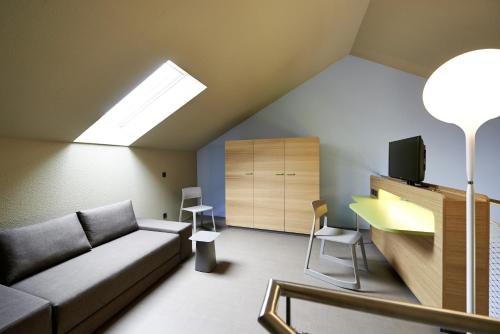 ein Wohnzimmer mit Couch und Schreibtisch in der Unterkunft Hotel mein inselglück in Reichenau
