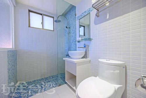 uma casa de banho com um WC branco e um lavatório. em Huaxin Hotel em Magong