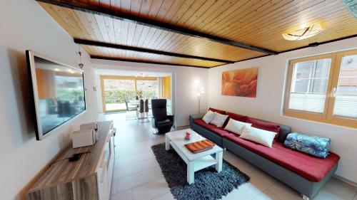 a living room with a red couch and a table at Chämihitta in Blatten bei Naters