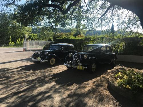two old cars parked on the side of a road at Hotel Les Chênes in Sisteron