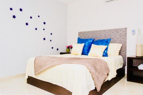 1 dormitorio con 1 cama grande con almohadas azules en Superior Studio 40 Aquamarina Suites, en Playa del Carmen