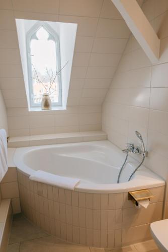 a bath tub in a bathroom with a window at Cavalierhaus Branitz in Cottbus
