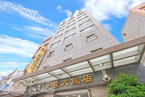 a tall white building with chinese writing on it at Huaxin Hotel in Magong