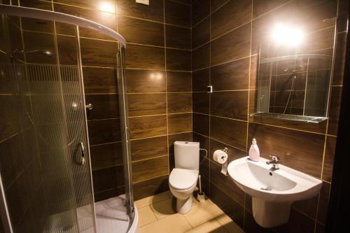 een badkamer met een toilet, een wastafel en een douche bij Hostel Soleil in Kutno
