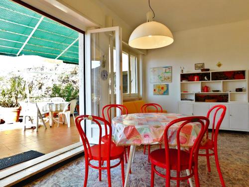 a dining room with a table and red chairs at Attico vista mare in Levanto