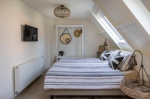 a bedroom with a king sized bed in a attic at De Heerlijkheid van Noordwelle Adults Only in Noordwelle