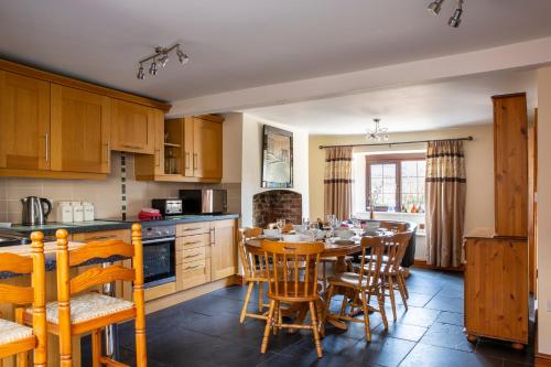 a kitchen with a wooden table and chairs and a dining room at Herefordshire Holiday Cottages in Lea