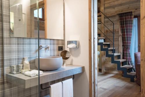 a bathroom with a sink and a staircase at Auberge de La Maison in Courmayeur