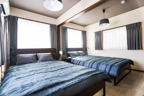 two beds in a bedroom with two windows at Funabashi-honchou 4choume kodate #MF1 in Funabashi