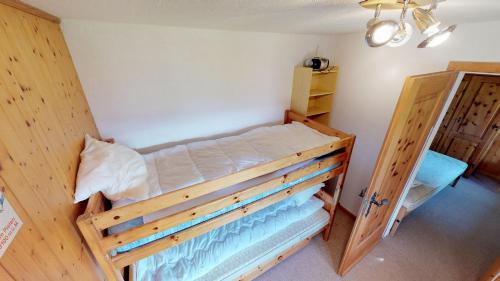 ein Schlafzimmer mit einem Etagenbett aus Holz in einem Zimmer in der Unterkunft Vergissmeinnicht in Blatten bei Naters