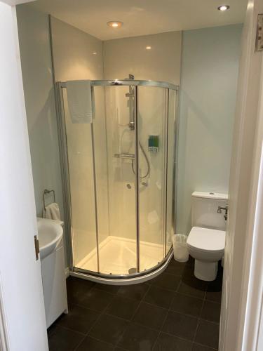 a bathroom with a shower and a toilet at Ivy Cottage-Serviced accommodation in Dyce
